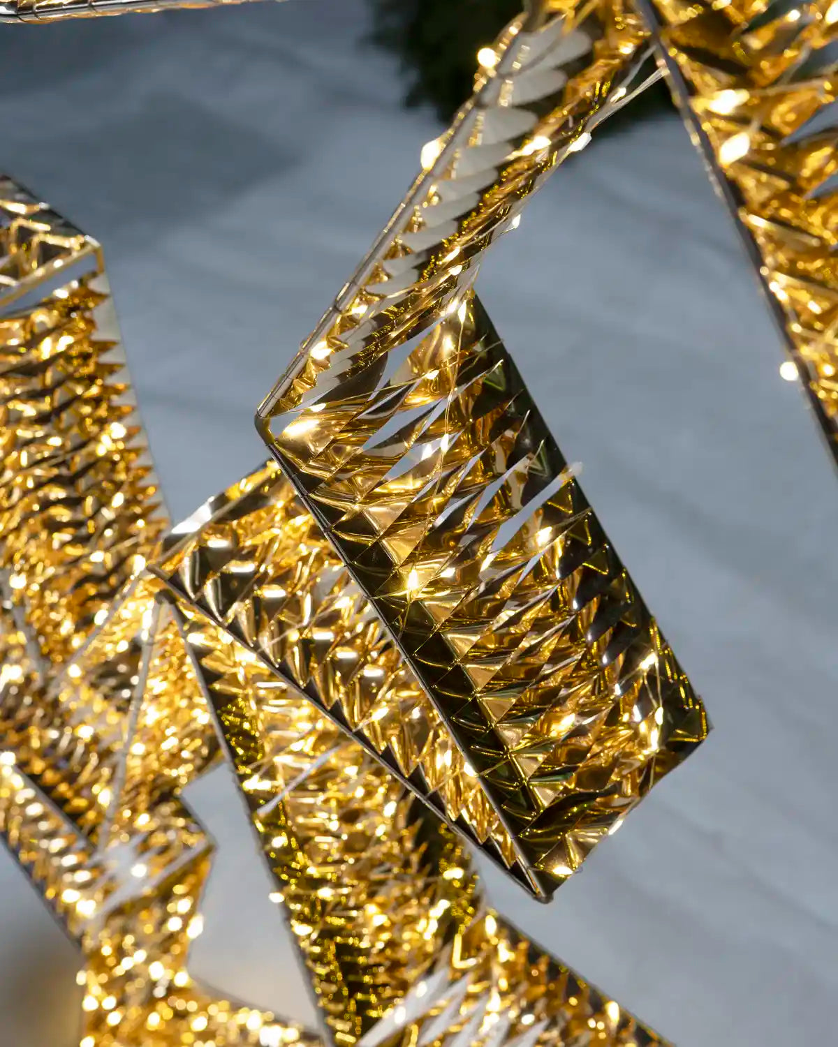 Close-up of the gold star decoration showing its reflective faceted metallic finish and integrated LEDs.