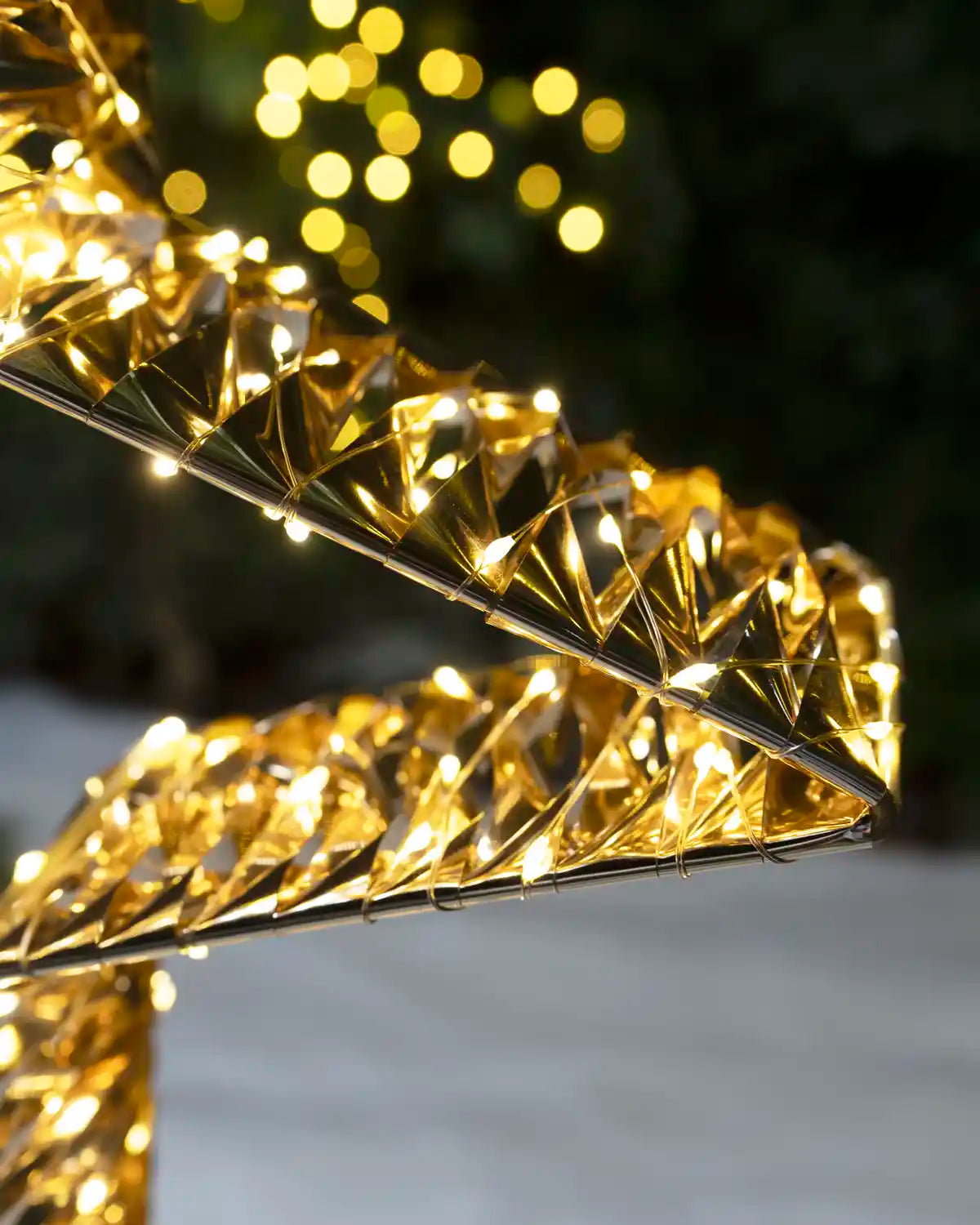 Close-up of warm white LED lights wrapped around the reflective gold star frame.