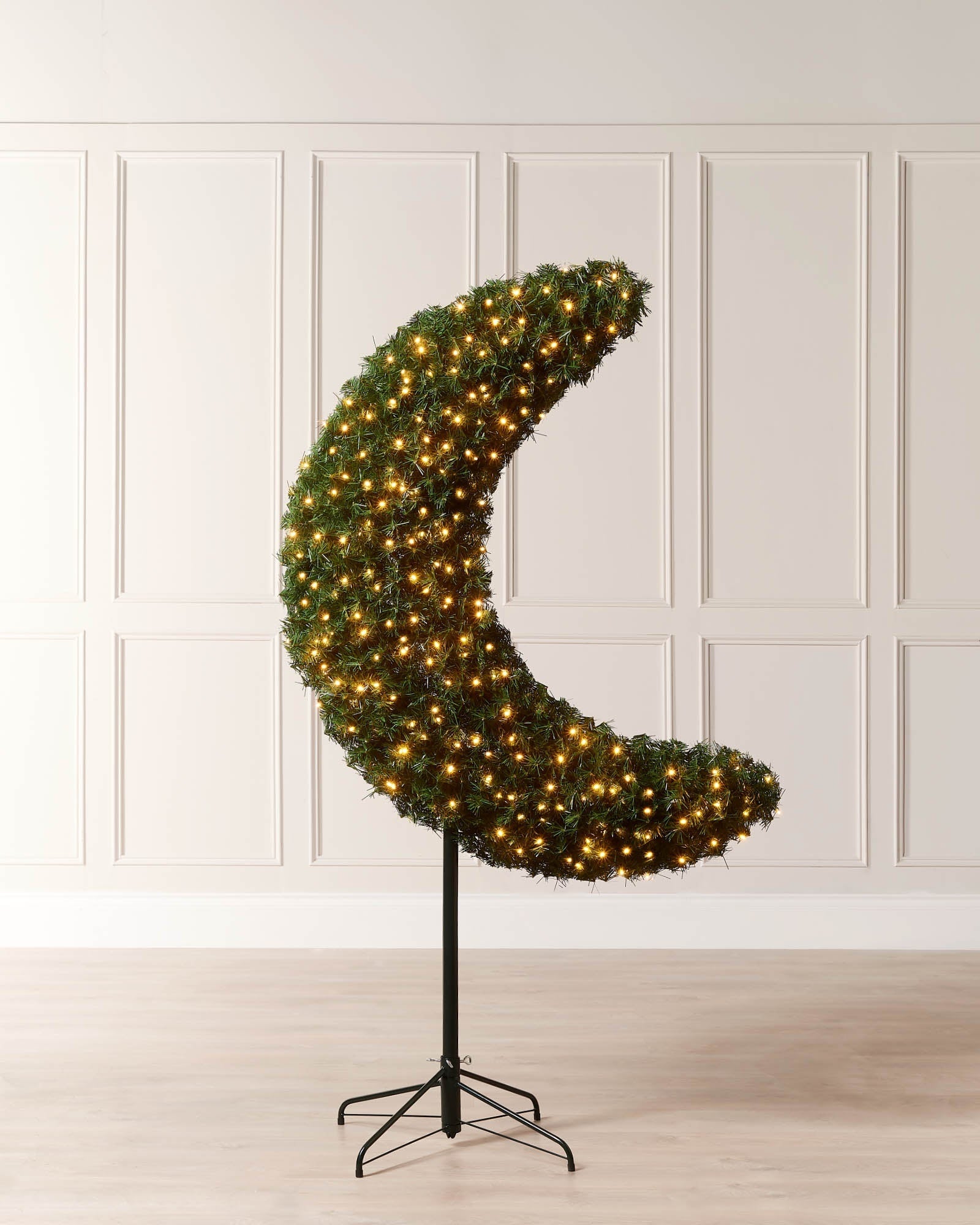 6ft pre-lit half moon Christmas tree with warm white lights displayed indoors on a metal tree stand.