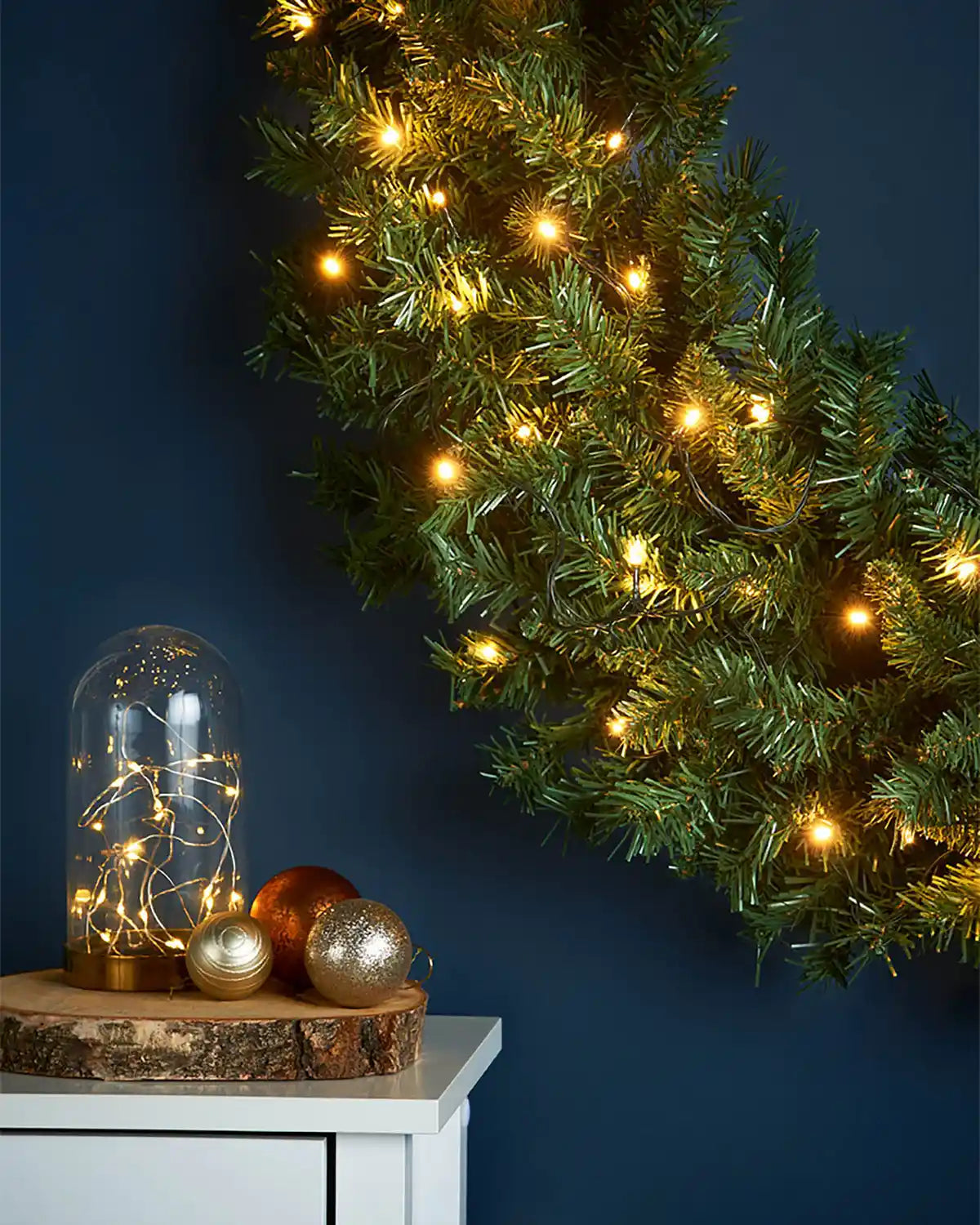 Close-up of the pre-lit majestic wreath with green foliage and warm white LED lights