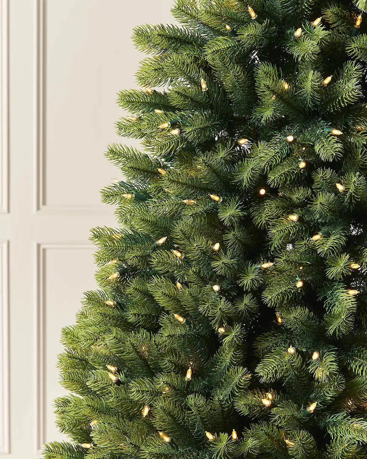 Close-up of mixed pine branches with warm white LED lights.