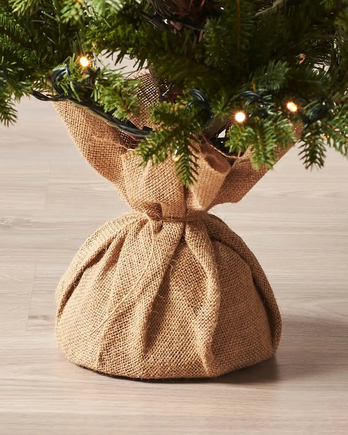 Hessian-wrapped base of a potted artificial Christmas tree