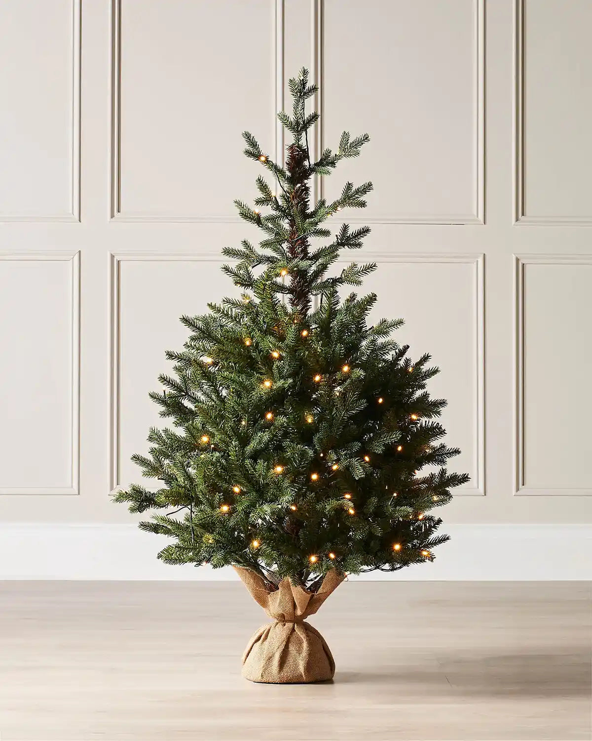 4 ft green artificial Christmas tree with warm lights displayed in a room