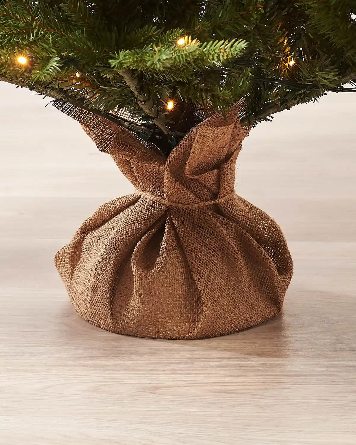 Hessian-wrapped base of a potted artificial Christmas tree