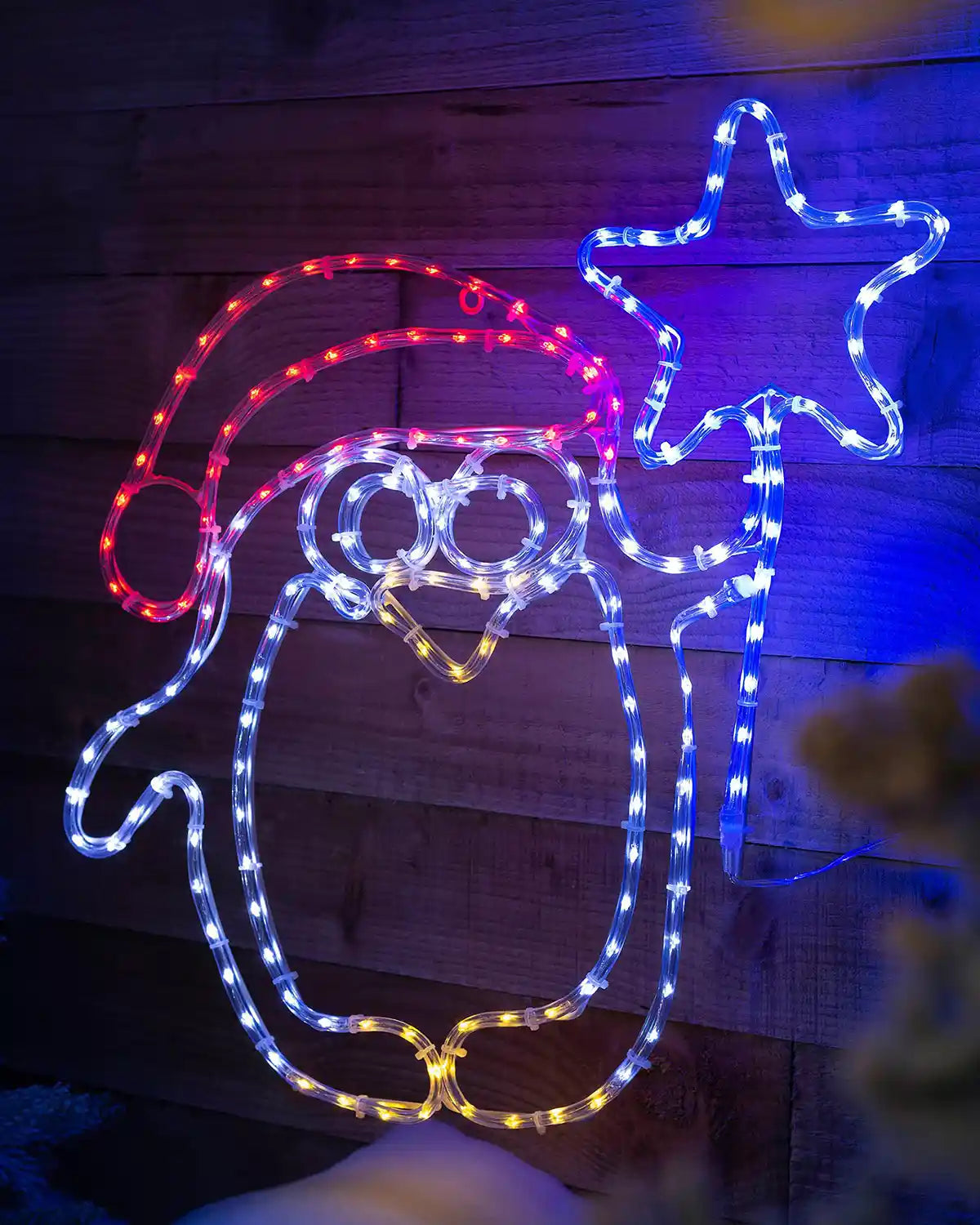 Pre-lit penguin and star silhouette displayed on a wooden wall