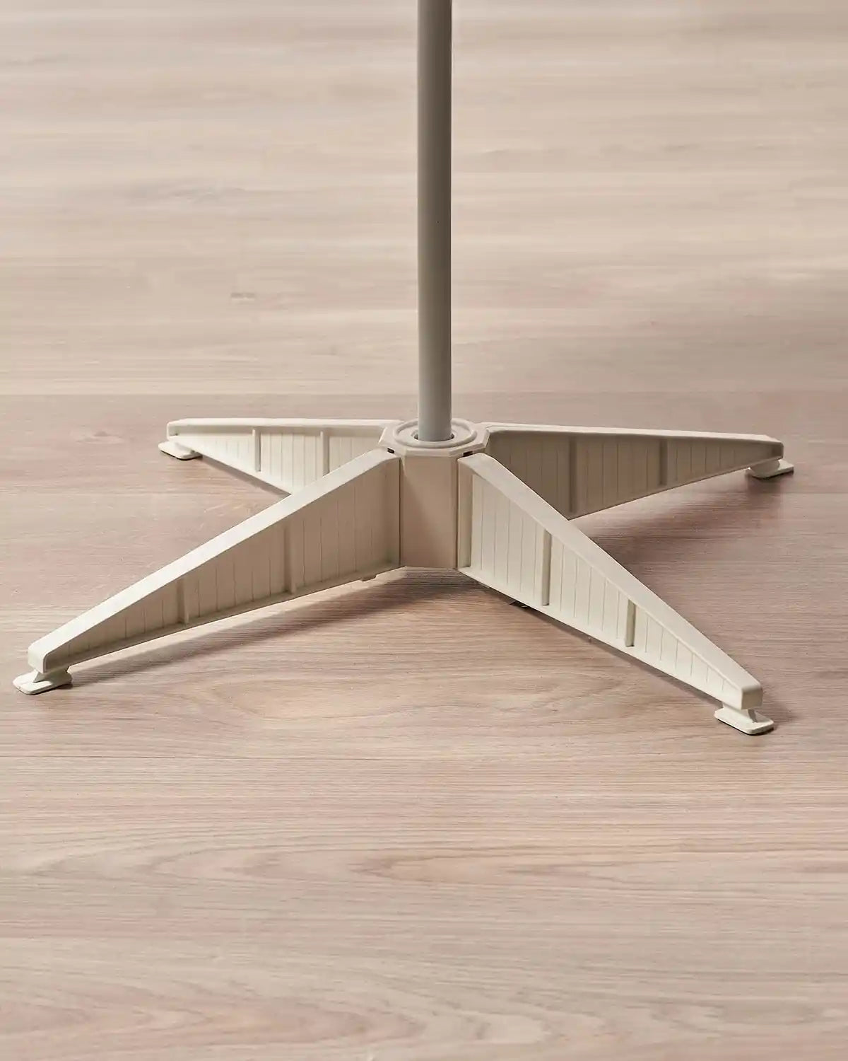 Close-up of the white stand base for the 6 ft pre-lit pop-up decorated Christmas tree