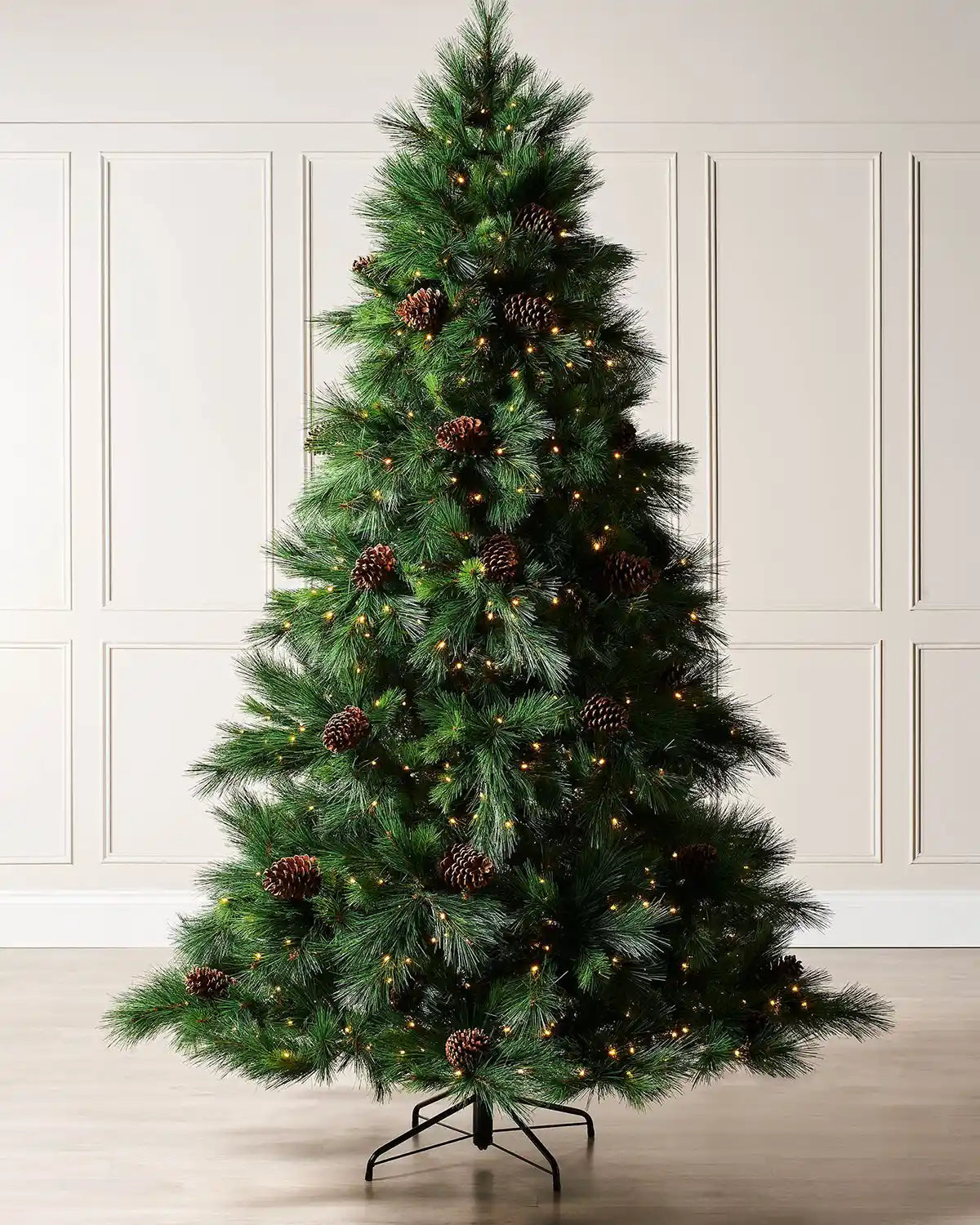 7.5 ft pre-lit Portland Spruce Christmas tree with pinecones and warm white lights in a room setting