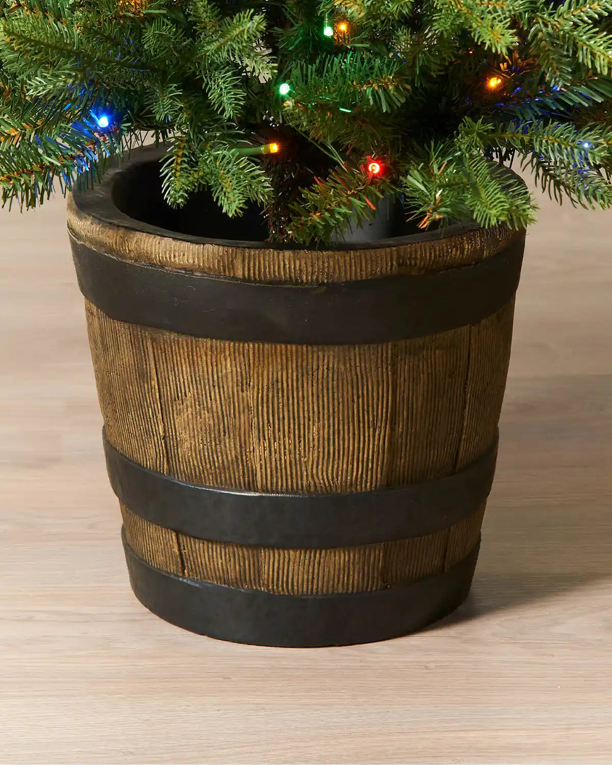 Close-up of the rustic barrel-style pot on a 4 ft pre-lit potted pine Christmas tree