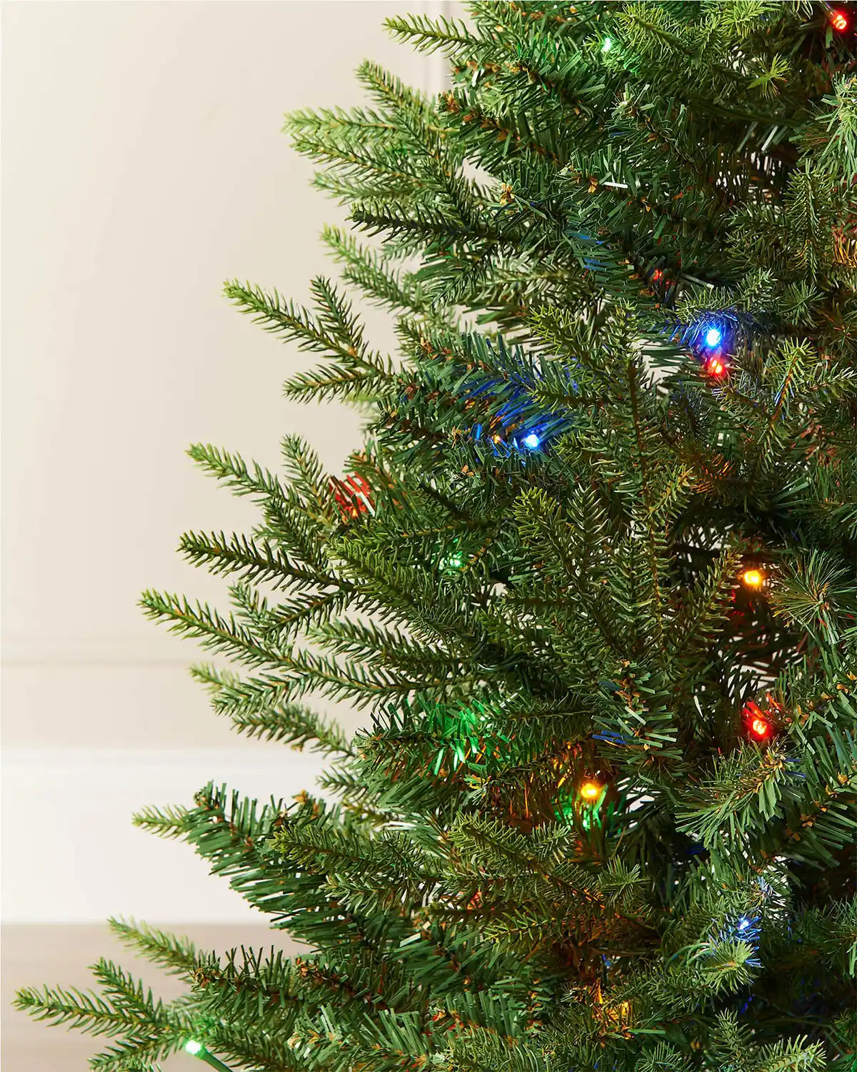 Close-up of 4 ft pre-lit potted pine Christmas tree branches with multicoloured LED lights