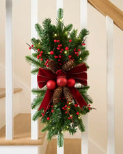 Pre-lit 60 cm red and burgundy Christmas garland swag with berries, pinecones, baubles and velvet bow.