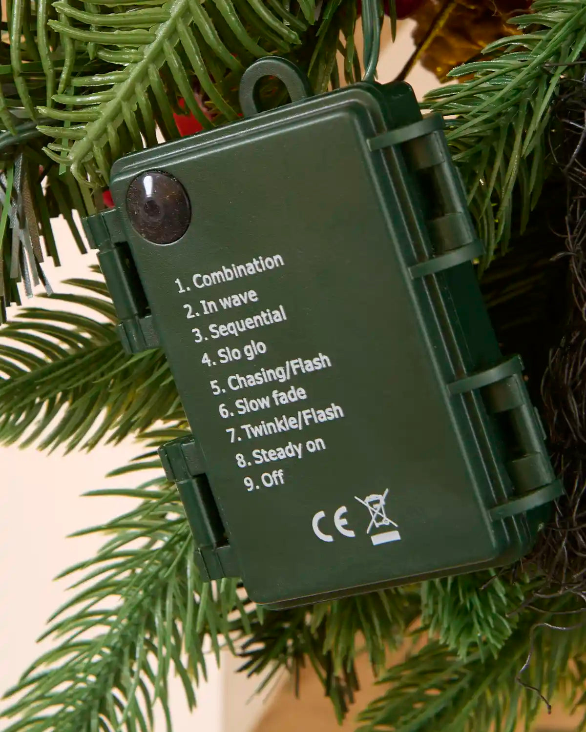 Close-up of the green battery box showing the garland swag's selectable lighting functions.