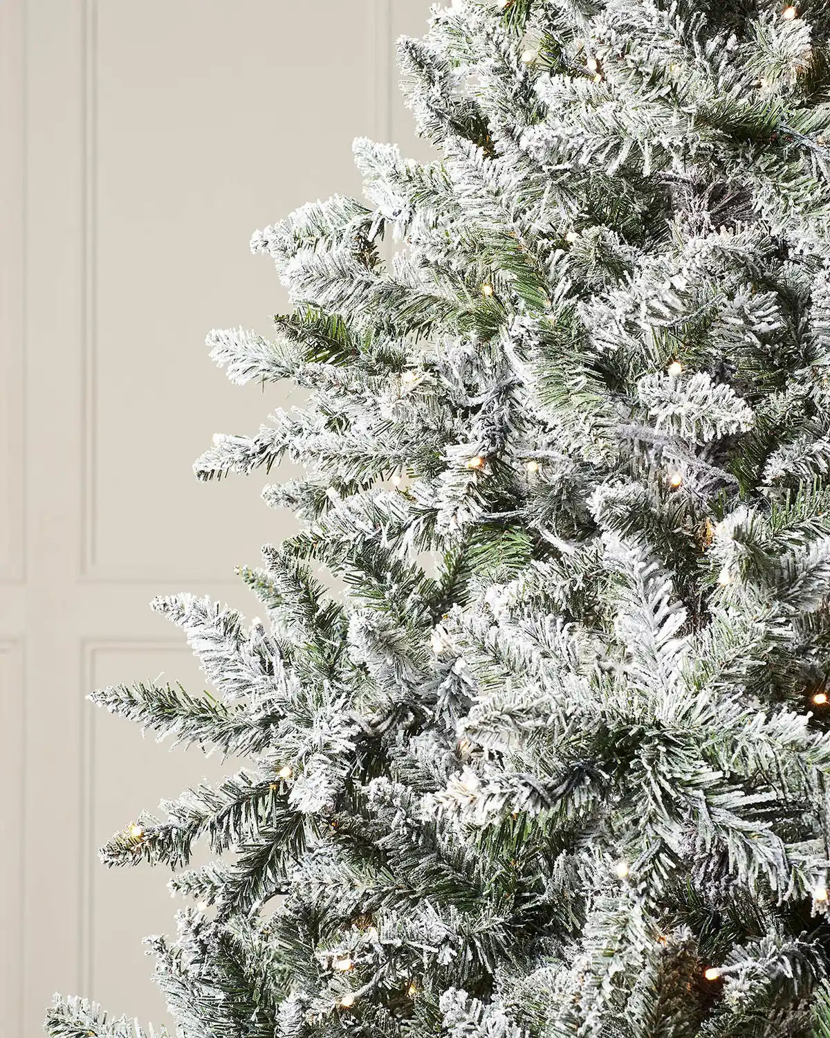 Close-up of the snow flocked branches and warm white LEDs on the pre-lit Christmas tree.