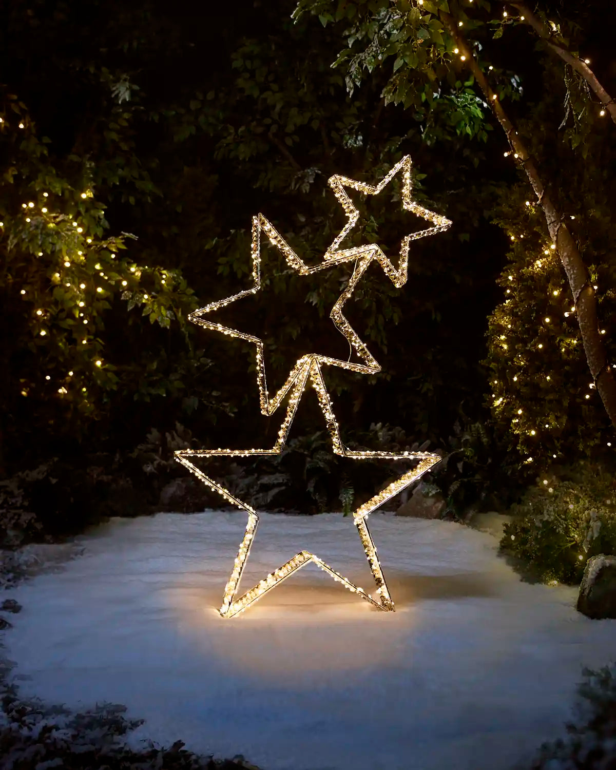 Pre-lit 140 cm gold star stack illuminated with warm white LEDs in an outdoor festive setting.