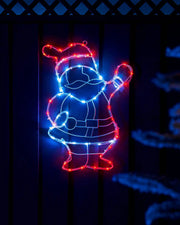 Pre-lit waving Santa silhouette displayed on a wooden wall at night