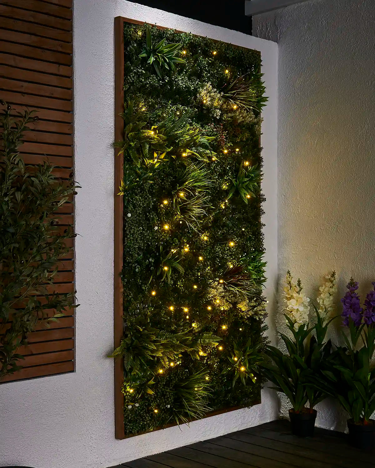 Gold Pro Series string lights displayed across a green outdoor living wall.
