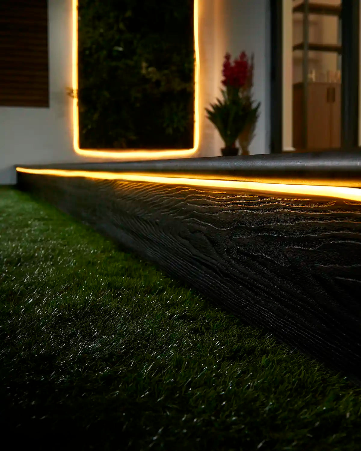 Warm white Pro Series Neon Flex installed along outdoor decking and a wall feature.