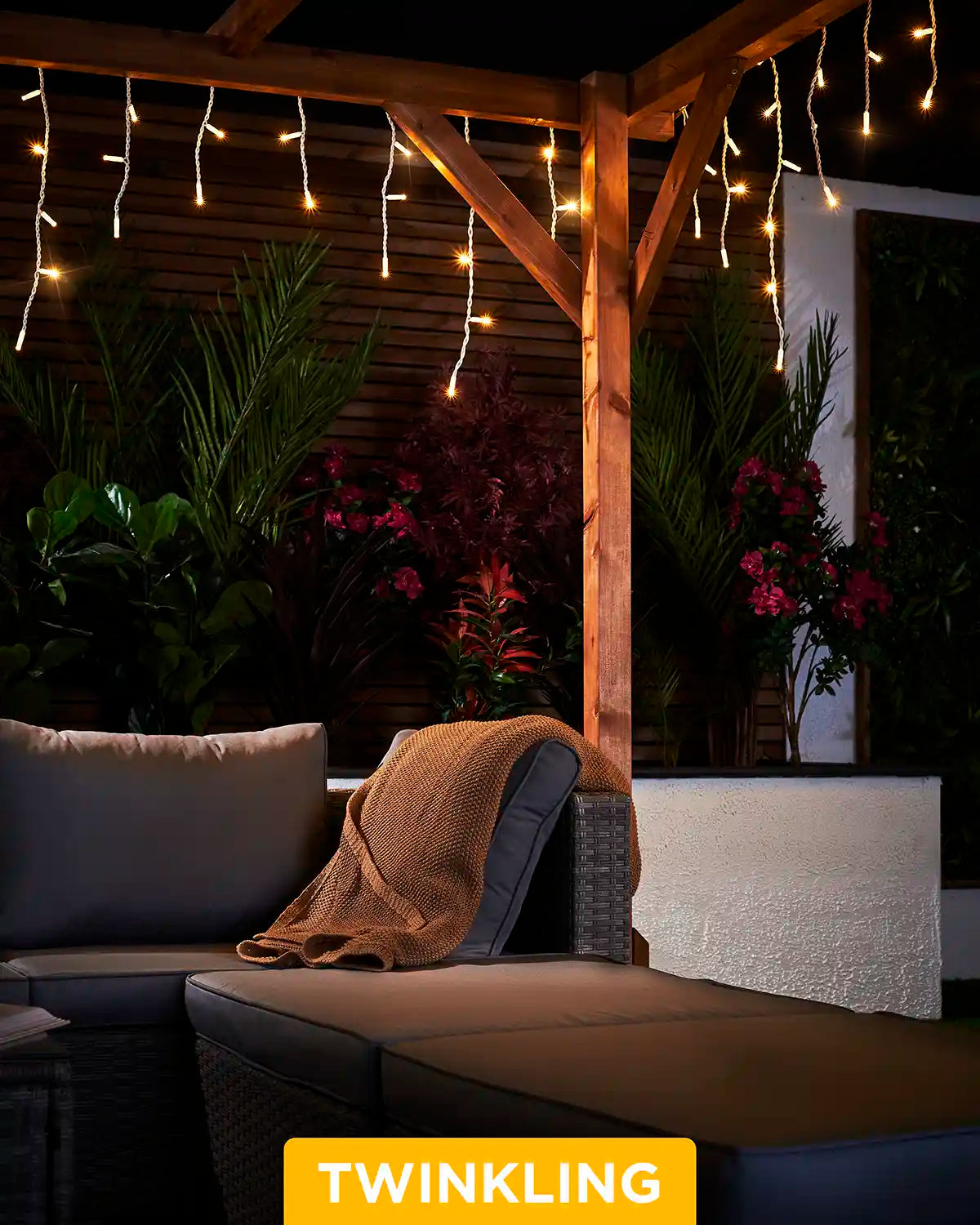 Warm white twinkling icicle lights hanging from a wooden pergola above outdoor seating.