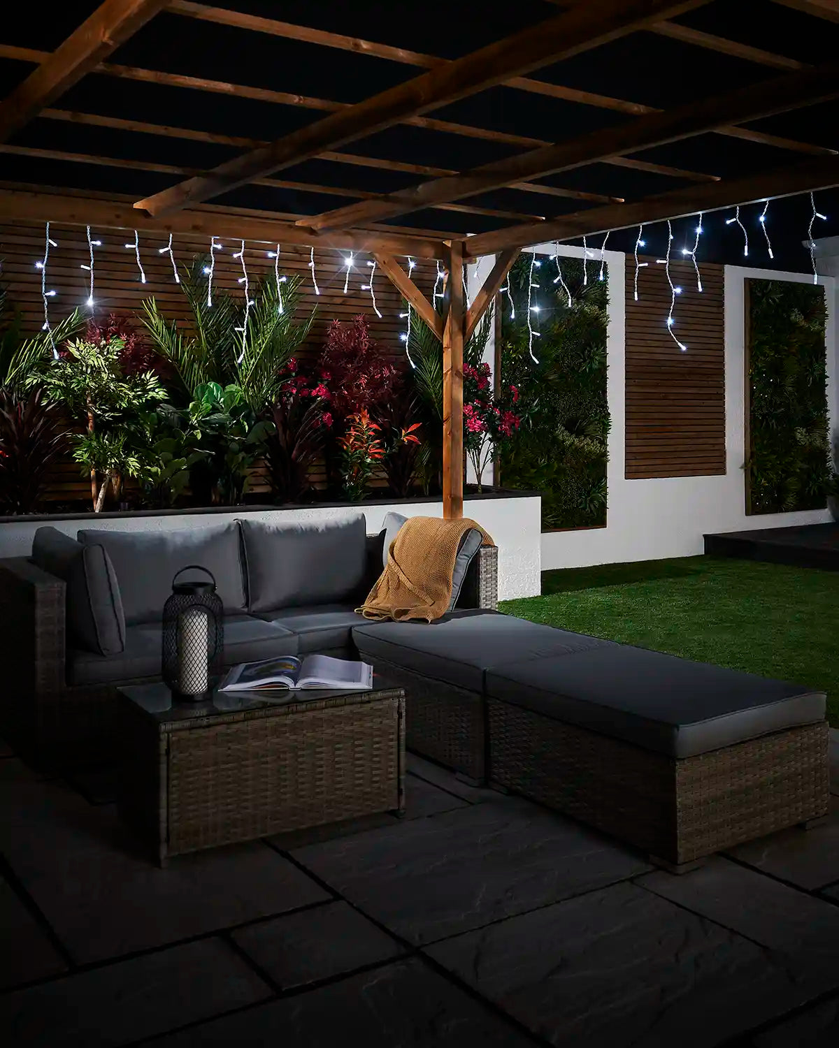 White twinkling icicle lights displayed over an outdoor seating area.