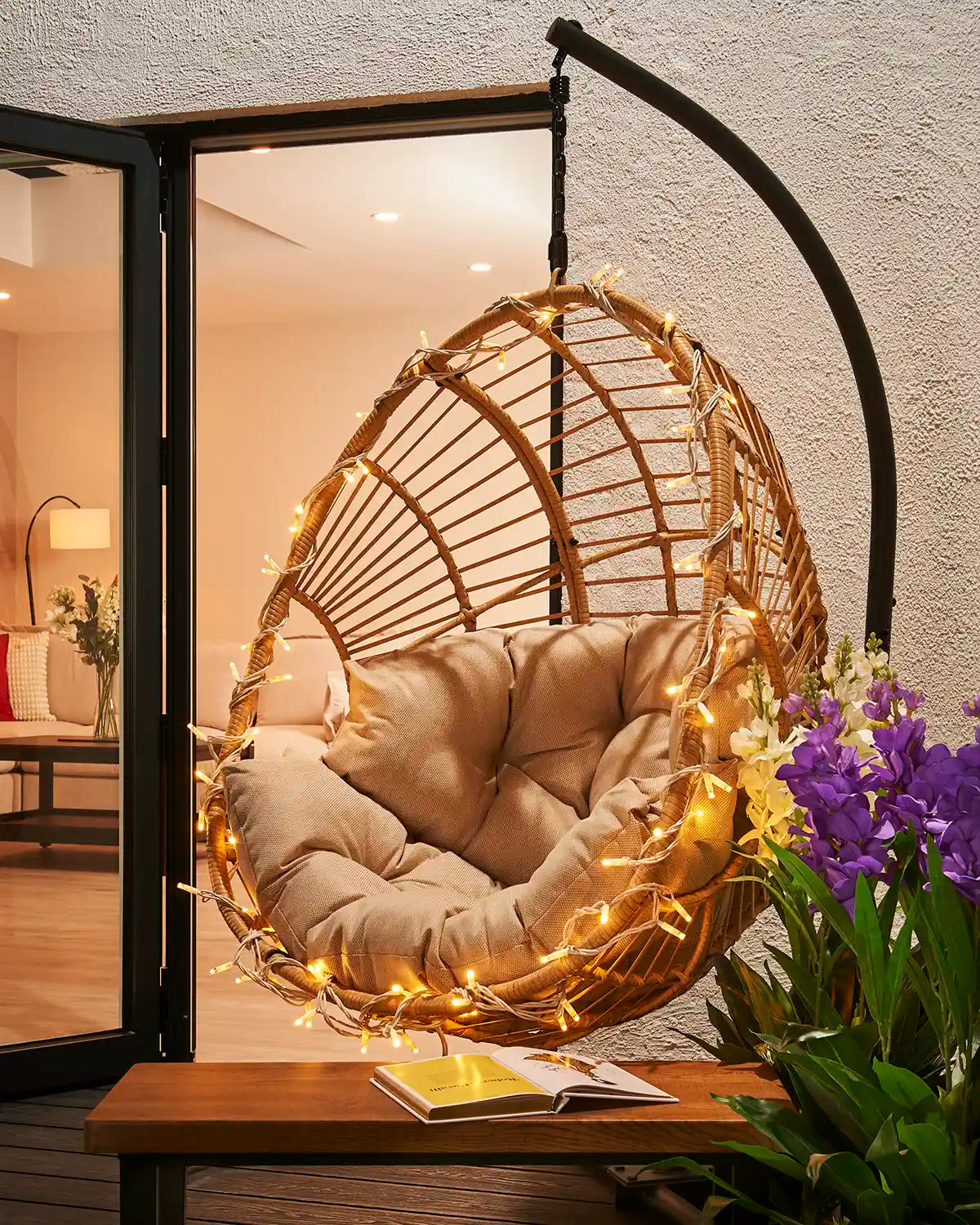 Warm white Pro Series string lights with white cable wrapped around an outdoor hanging chair.