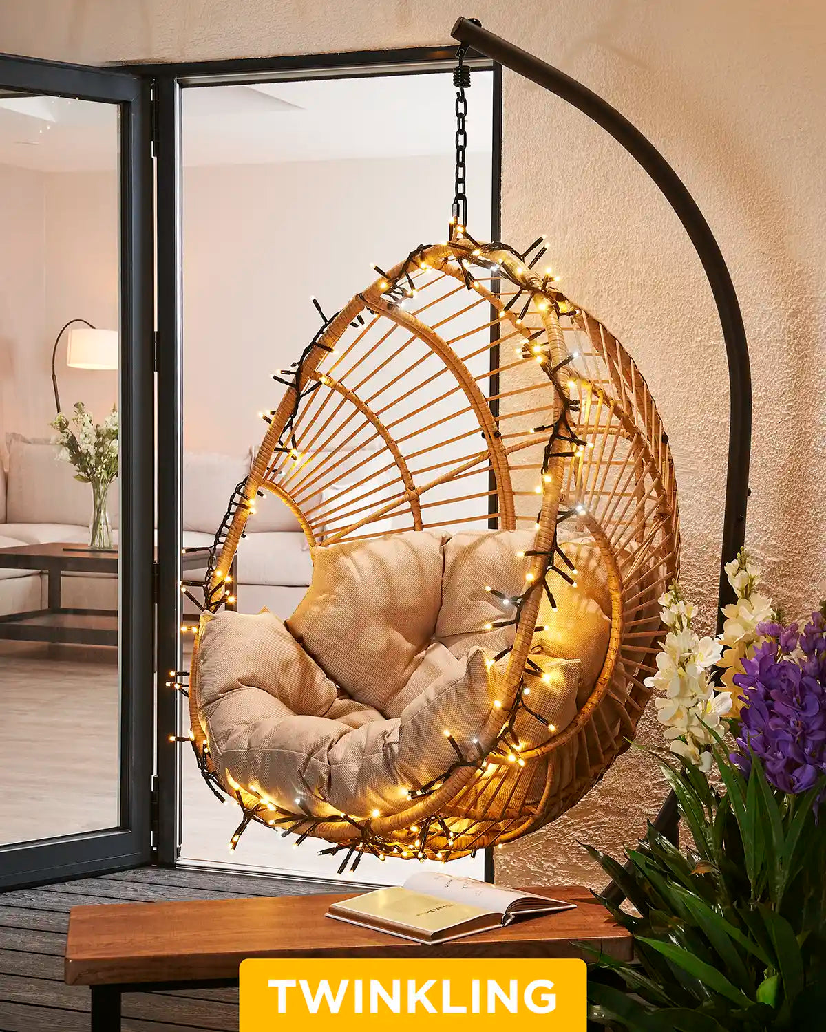 Mixed warm white and white cluster lights wrapped around a hanging garden chair.