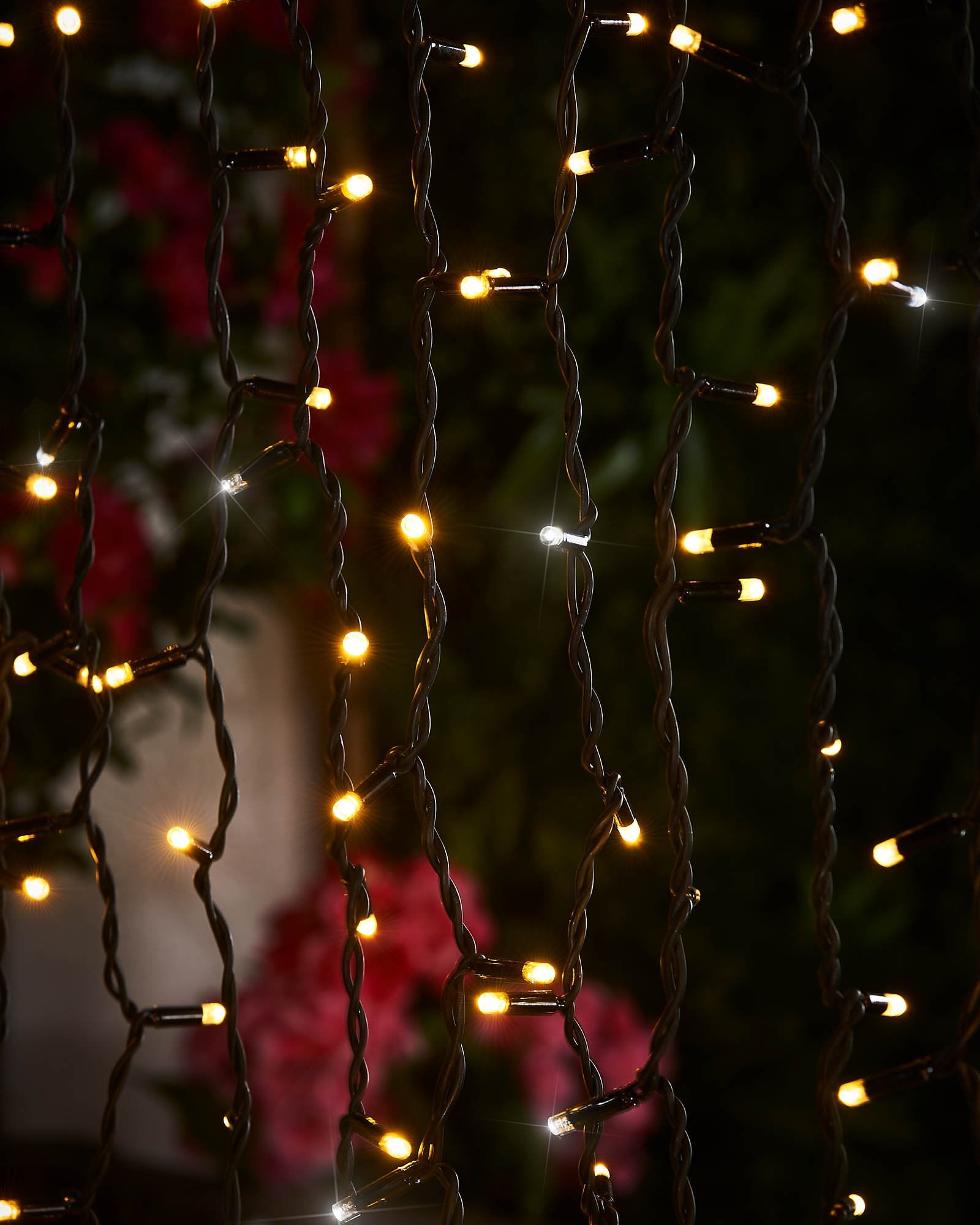 Detailed close-up of warm white and white LEDs hanging from black cable curtain lights.