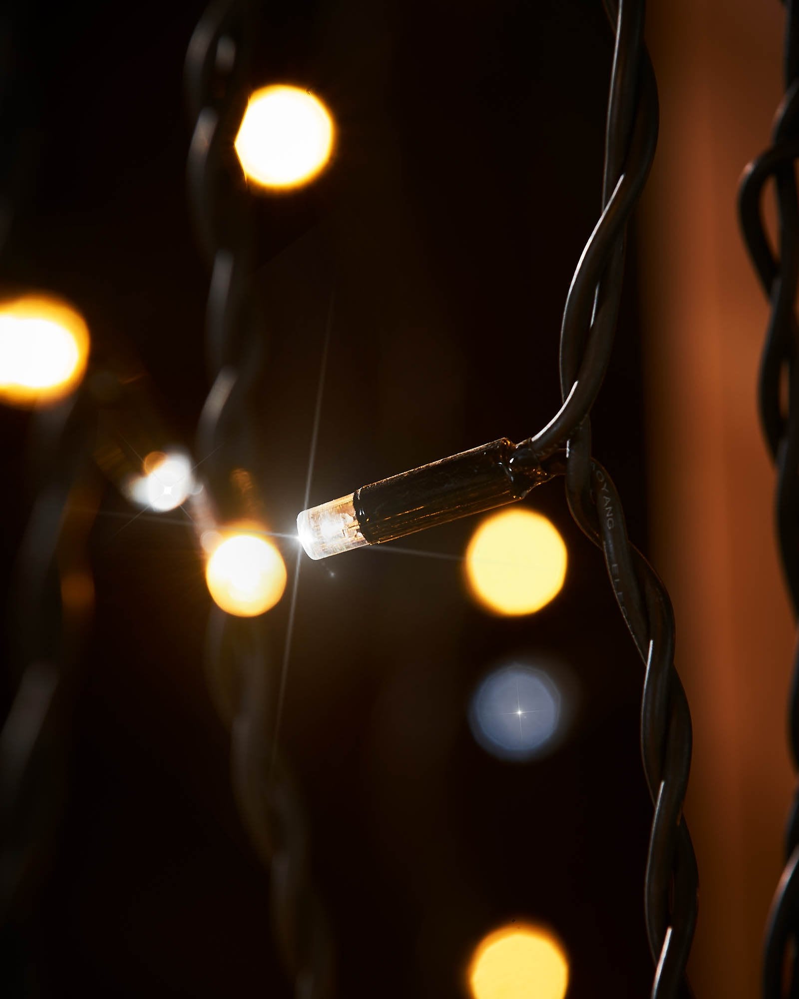 Close-up of a warm white and white LED on black cable curtain lights.