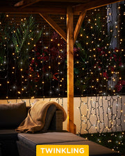Warm white and white curtain lights with a 2.5m drop displayed around an outdoor patio seating area.