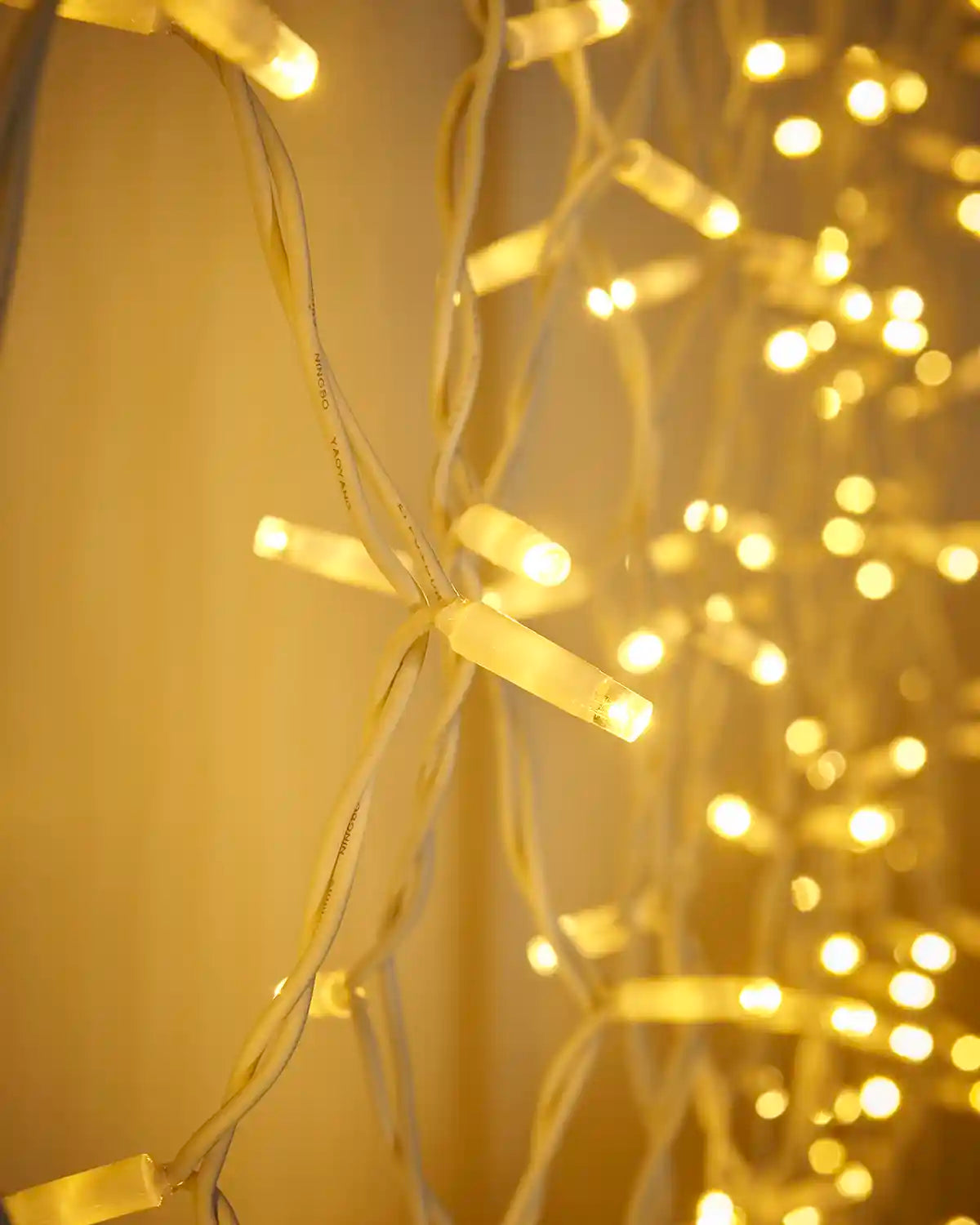 Close-up of warm white and white LEDs on a white cable curtain light display.