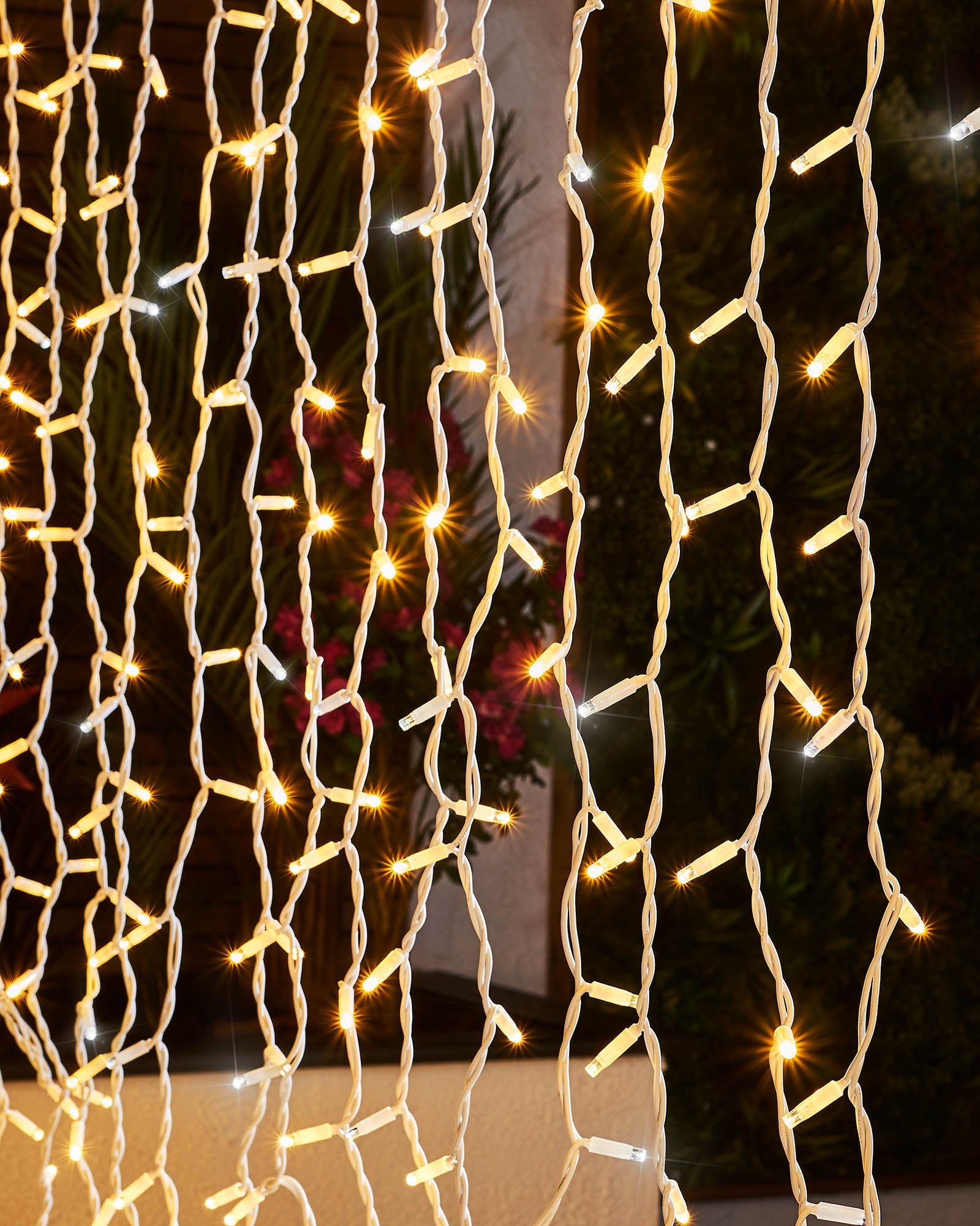 Detailed close-up of warm white and white LEDs hanging from white cable curtain lights.