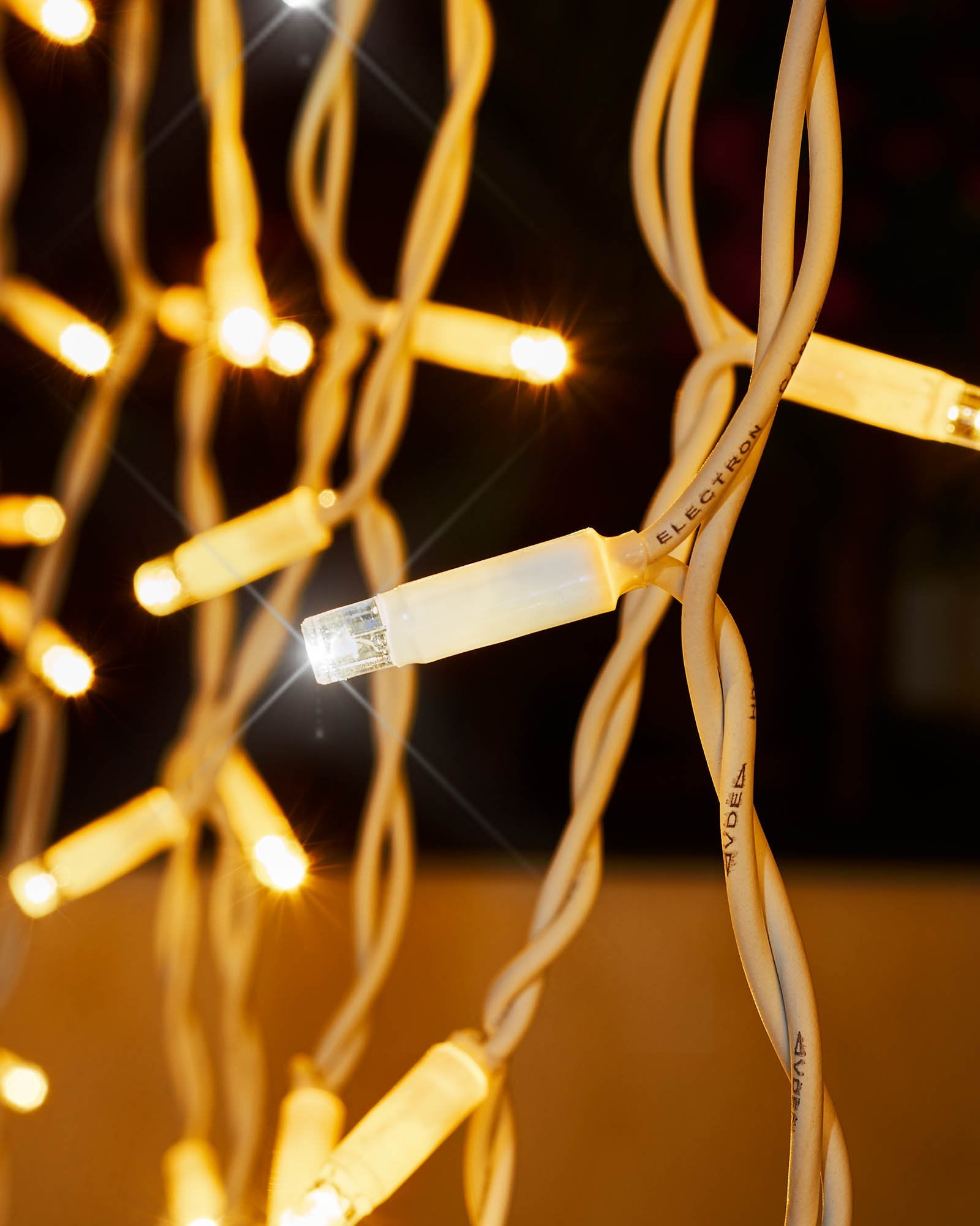 Close-up of warm white and white LEDs on white cable curtain lights.