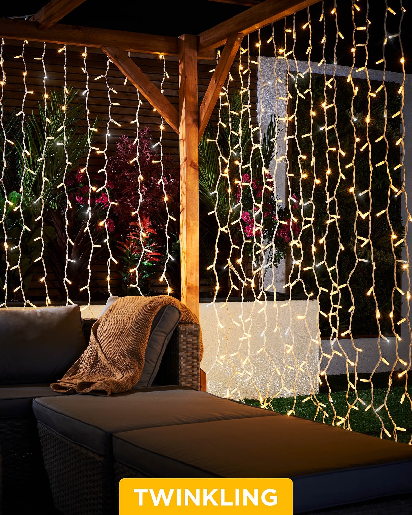 Warm white and white curtain lights with a 2.5m drop displayed around an outdoor patio seating area.