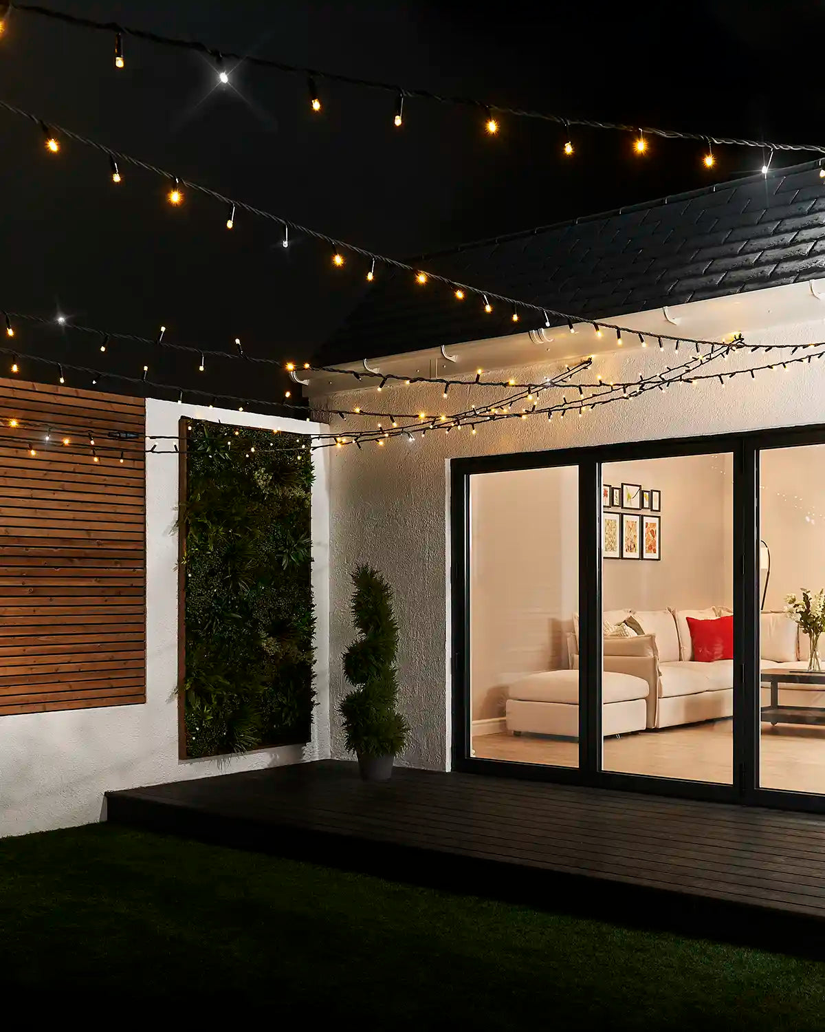 Mixed warm white and white twinkle string lights displayed above an outdoor patio seating area.