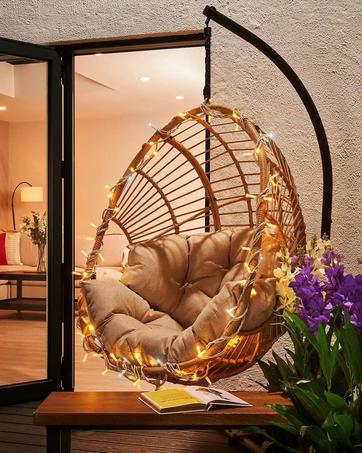 Mixed warm white and white twinkle string lights wrapped around a hanging garden chair.