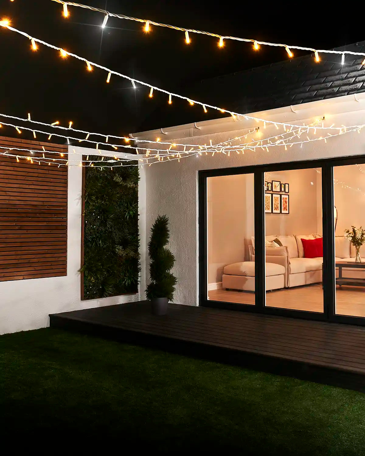 Mixed warm white and white twinkle string lights displayed above an outdoor patio seating area.