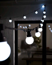 White festoon lights hanging across an outdoor patio area.