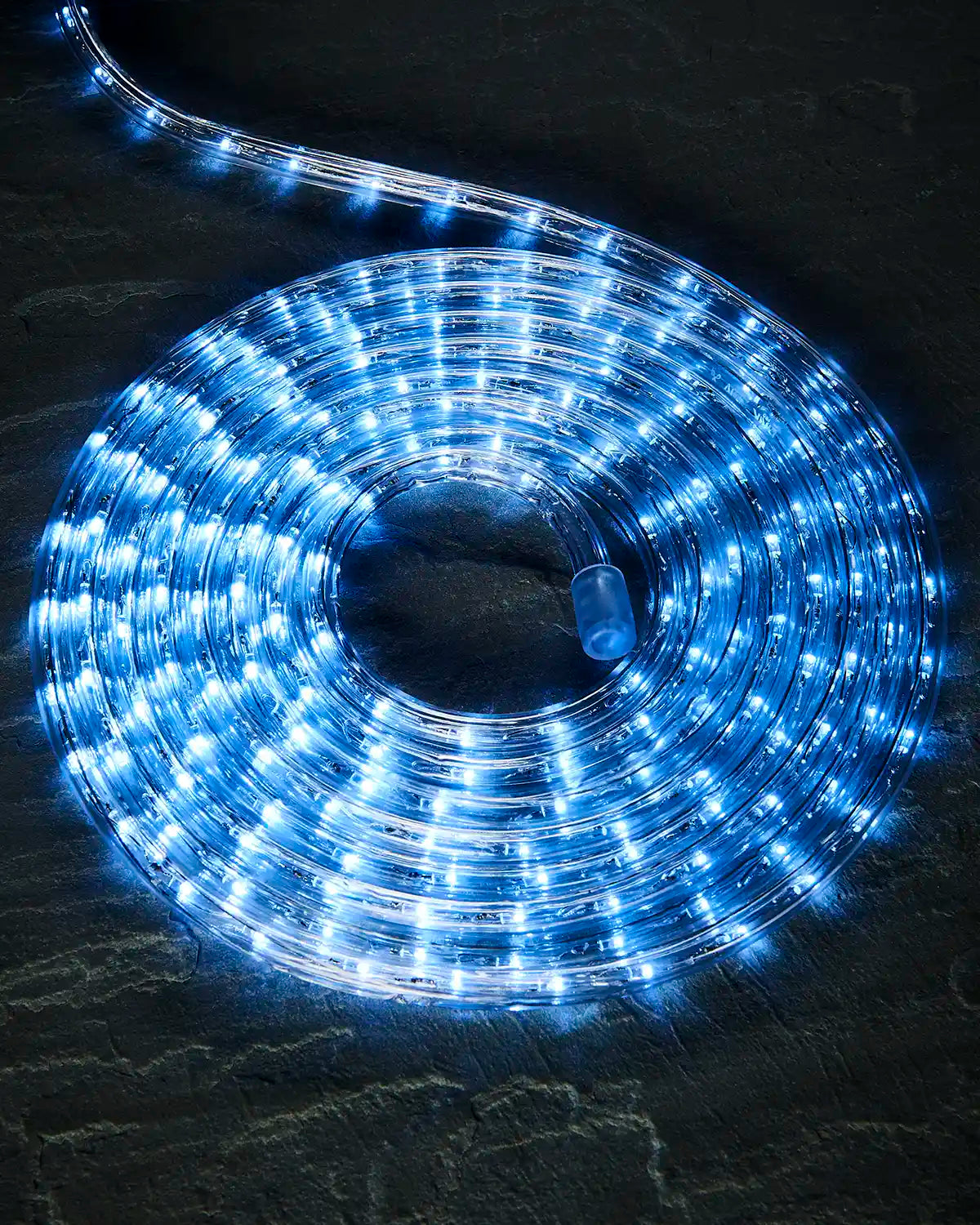 Coiled white Pro Series rope light on a dark surface with an endcap visible.