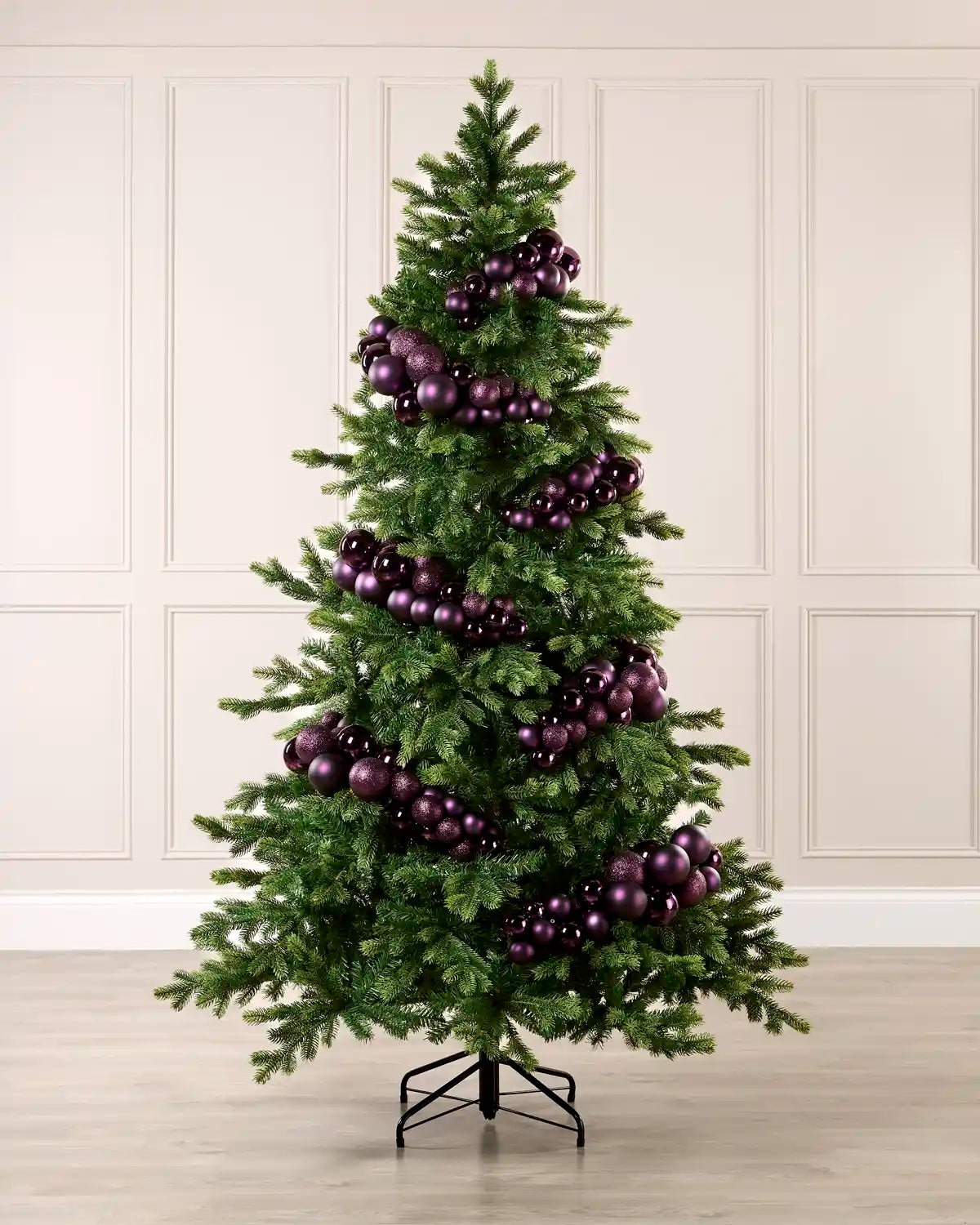 Purple bauble cluster arch styled around a green Christmas tree with shiny, matt and glitter baubles.