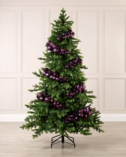 Purple bauble cluster arch styled around a green Christmas tree with shiny, matt and glitter baubles.