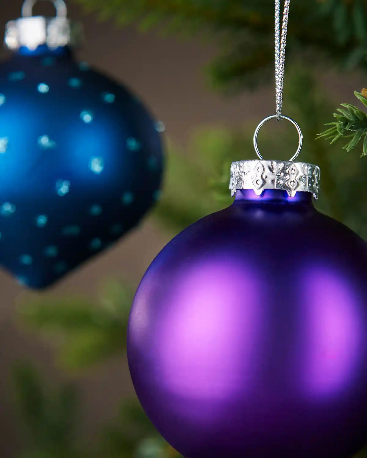 Purple glass round bauble hanging on Christmas tree