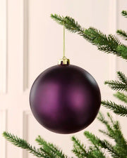 Purple 15 cm oversized shatterproof bauble with a smooth matt finish, gold cap and hanging string displayed on a Christmas tree.