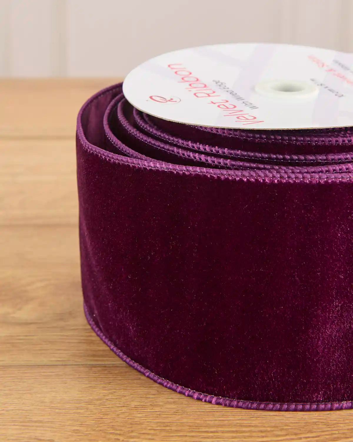 Close-up of 10 cm wide purple velvet ribbon showing its soft texture and wired edges.