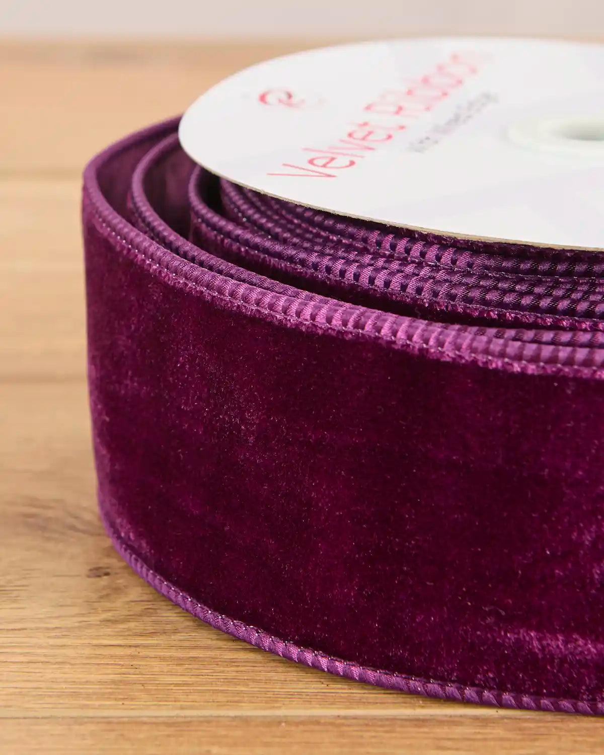 Close-up of 6 cm wide purple velvet ribbon showing the soft surface and wired edges.