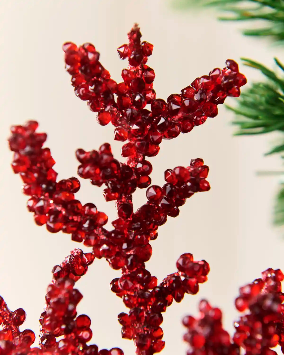 Detailed view of faceted red crystal beads clustered across the spray branches.