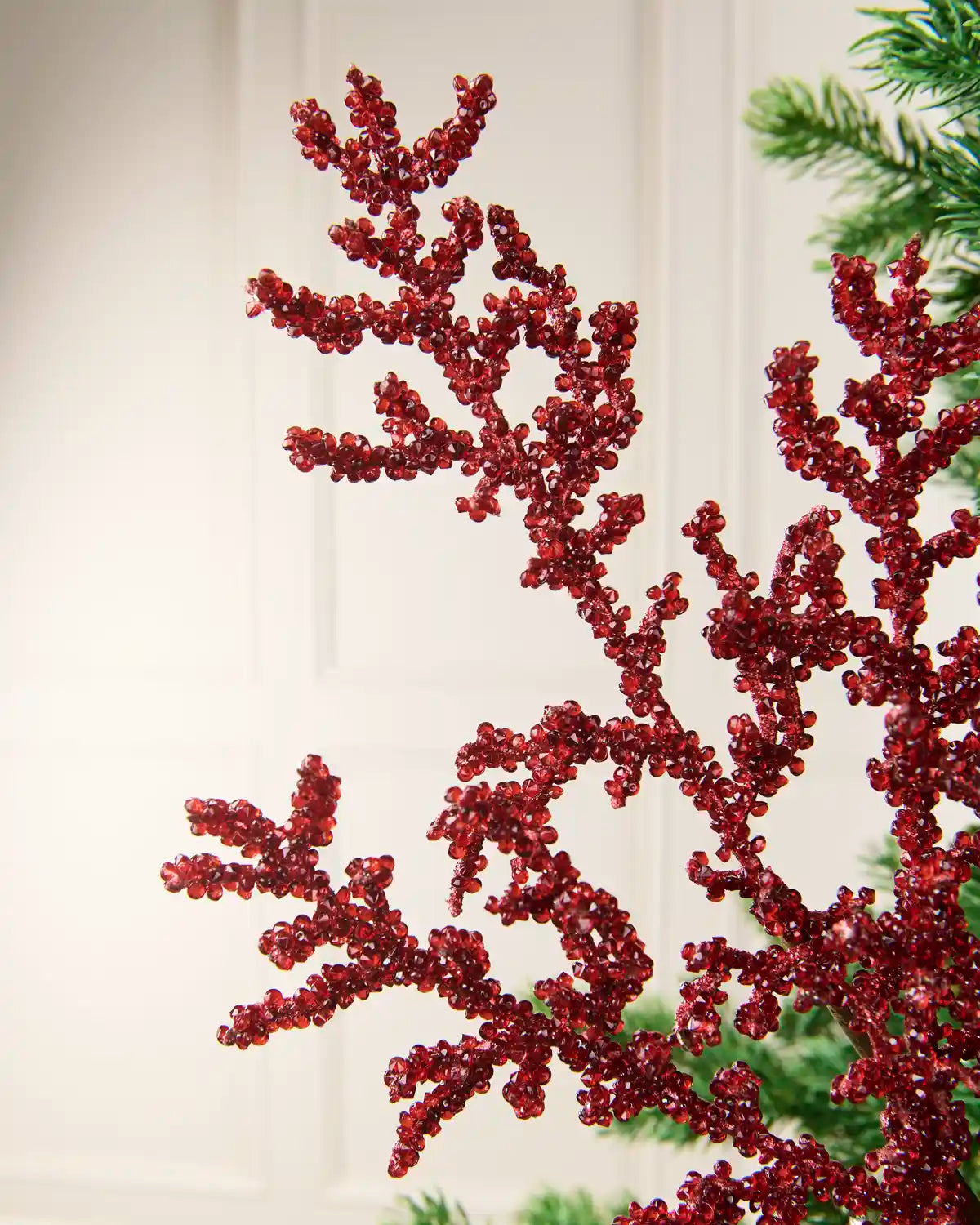 Close-up of red crystal beads densely arranged along branching decorative stems.