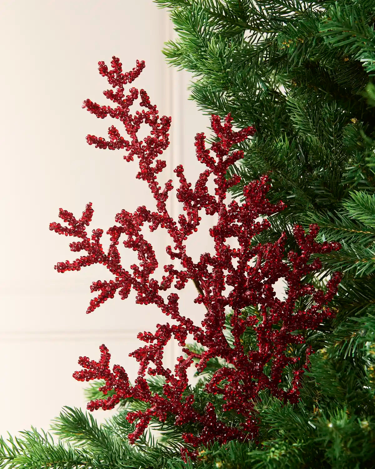 76 cm red beaded crystal spray arranged among green Christmas tree branches.