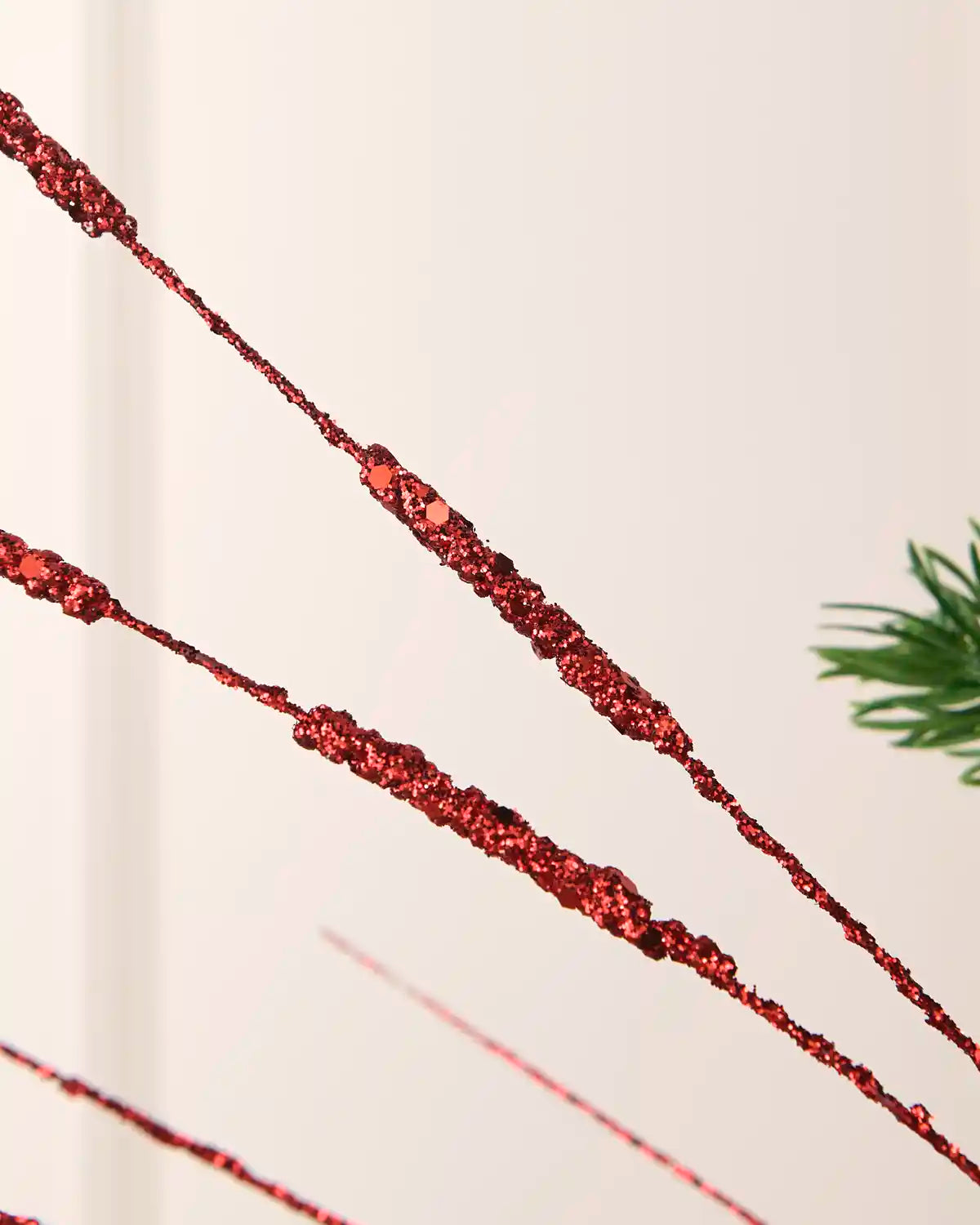 Detailed close-up of red glitter and sequin accents on the 100 cm wispy spray strands.