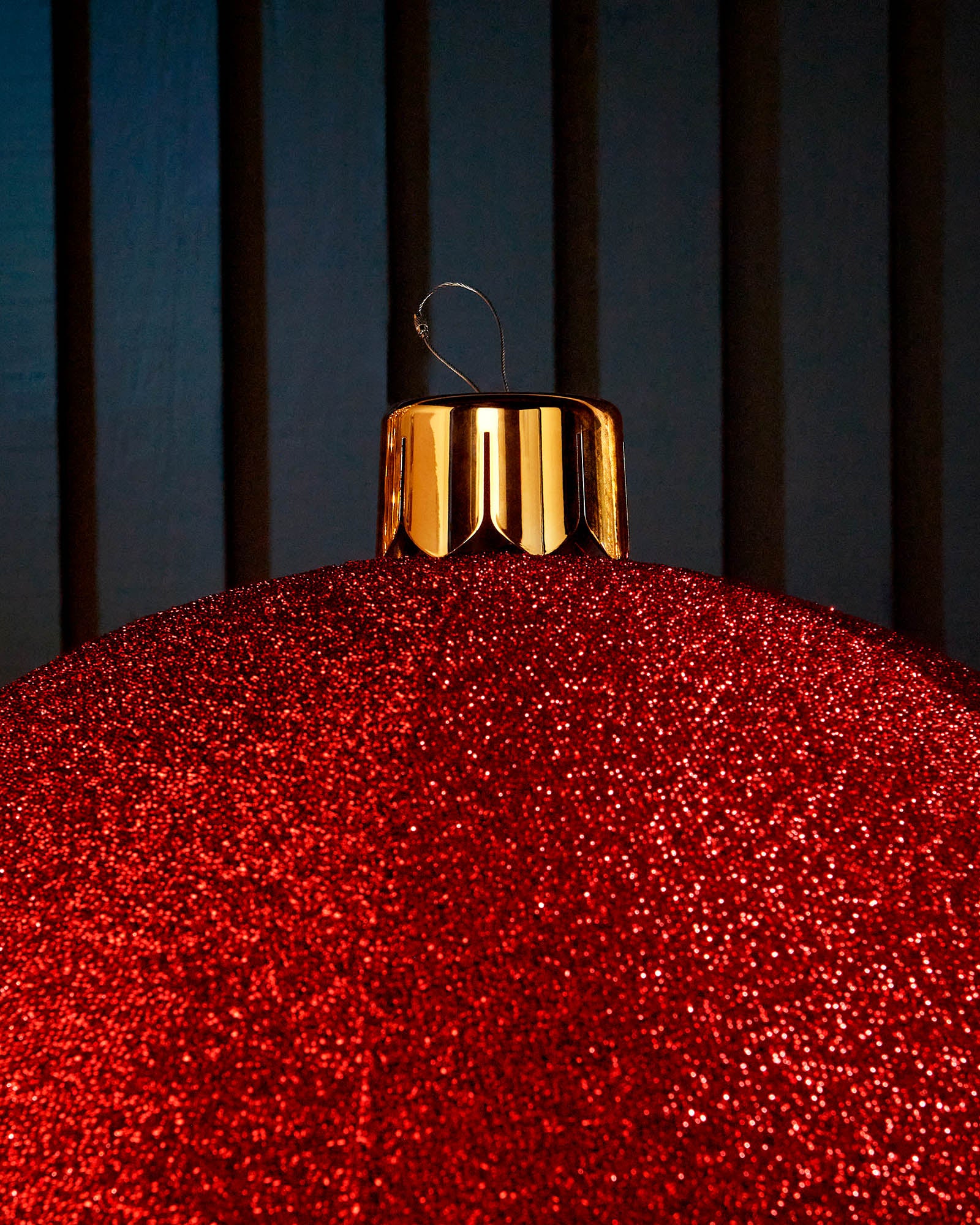 Close-up of the gold cap and hanging wire on a red inflatable tinsel Christmas bauble.