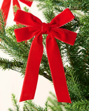 Red 16.5 cm velvet double bow with long tails attached to a Christmas tree branch.