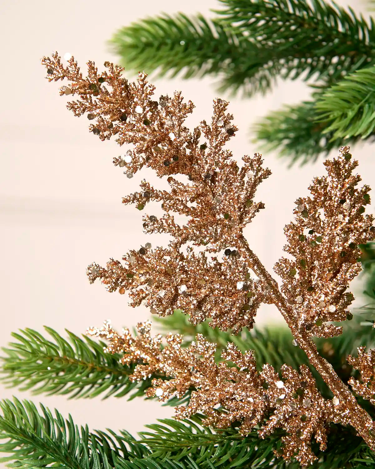 Close-up of a rose gold glitter leaf pick showing sparkling foliage and reflective sequin detail.