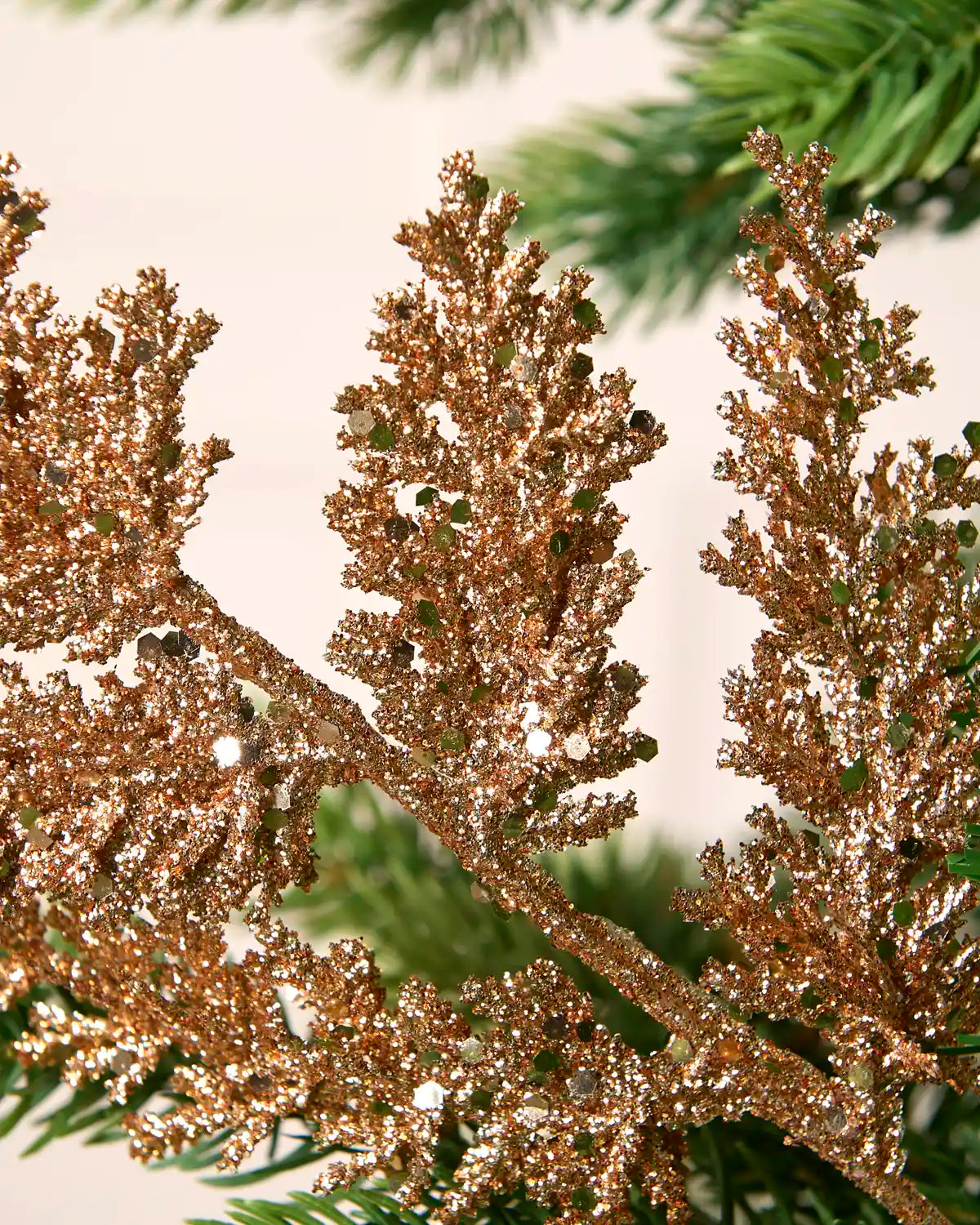 Detailed view of a rose gold glitter leaf pick with glitter-covered branches and reflective sequins.